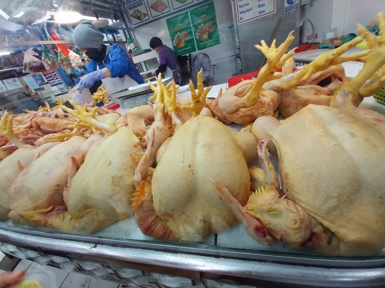 Pollos a precios altos en un puesto de mercado